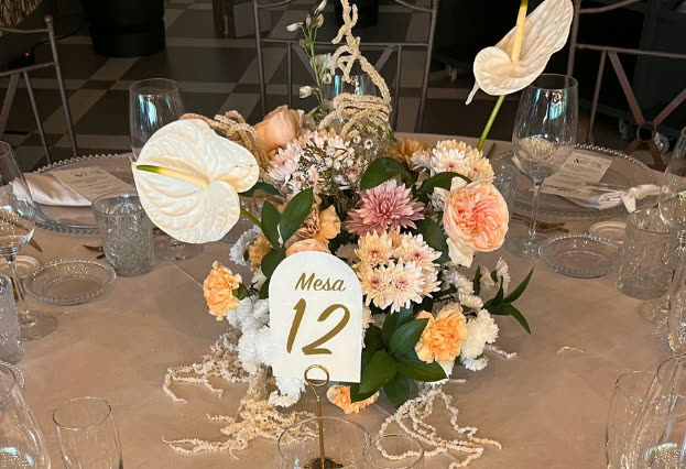 Centro de mesa con flores y numeración de mesa